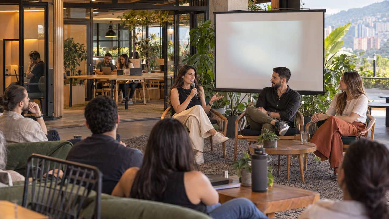 Moderadora y panelistas conversan frente a una audiencia pequeña